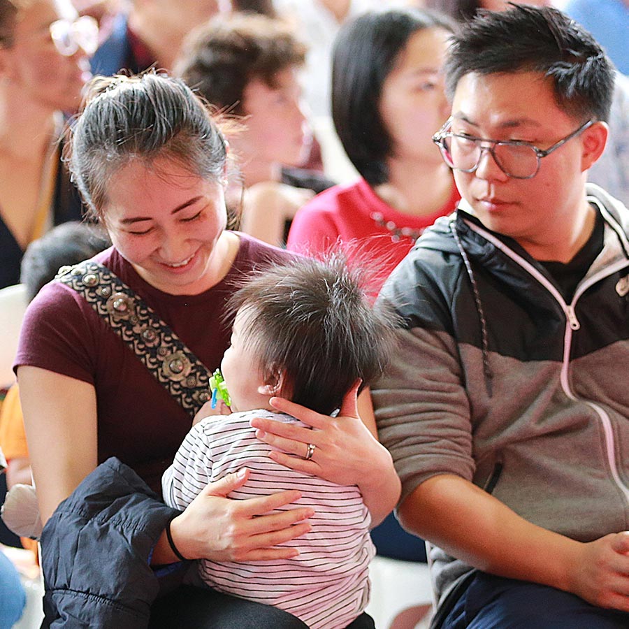 Parents and their child attending baby blessing ceremony